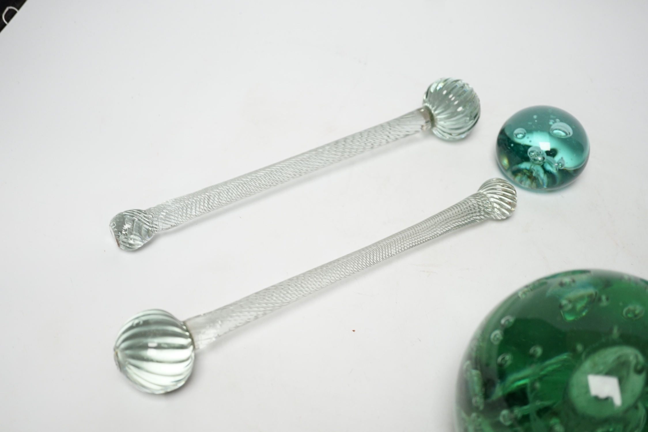 Three 19th century green glass Stourbridge dumps, one large, 12cm diam. and two small, 6cm diam., together with two glass batons, 25cm long